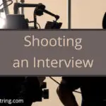 Shooting an Interview title card in front of a dark interviewer and a cameraman