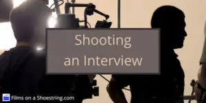Shooting an Interview title card in front of a dark interviewer and a cameraman